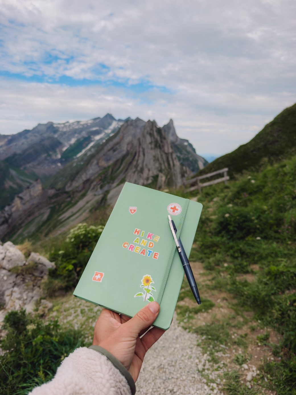 The Hike & Create journal held up in front of the Alpstein